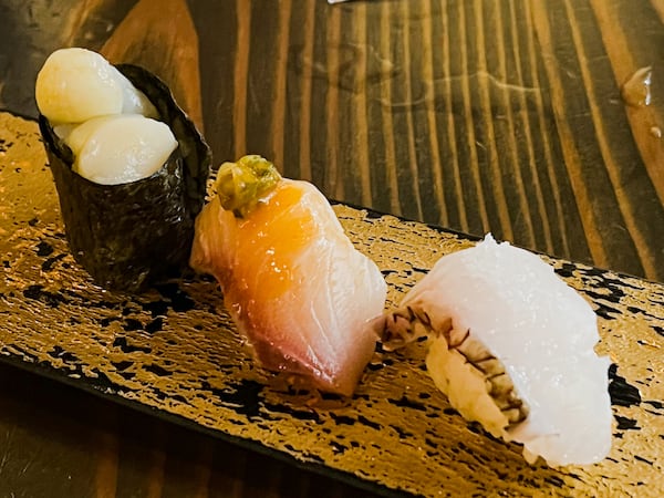 This nigiri course at Cuddlefish features (from left) bay scallops, yellowtail and sea bream. Henri Hollis/henri.hollis@ajc.com