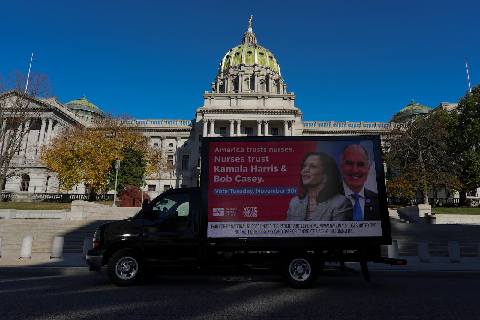 A truck displaying a banner supporting Kamala Harris in the presidential election parked in front of the Pennsylvania Capitol in Harrisburg, Pa., on Sunday, Oct. 27, 2024. (AP Photo/Luis Andres Henao)