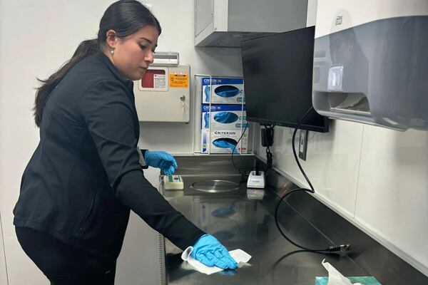 Kensley Atkins, a recent graduate of Clemson University, disinfects a countertop in September in one of the university’s mobile health units. Atkins completed an internship with Clemson’s rural health program during the fall semester and hopes to attend graduate school to become a physician assistant. (Lauren Sausser/KFF Health News)