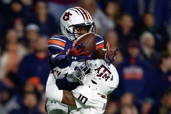 Auburn wide receiver KeAndre Lambert-Smith (5) catches a pass over Texas A&M defensive back Dezz Ricks (10) during the second half of an NCAA college football game, Saturday, Nov. 23, 2024, in Auburn, Ala. (AP Photo/Butch Dill)