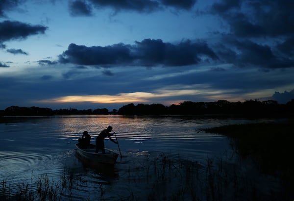 Members of the Mura Indigenous community maneuver a boat in the Lago do Soares village in Autazes, Amazonas state, Brazil, Monday, Feb. 17, 2025. (AP Photo/Edmar Barros)