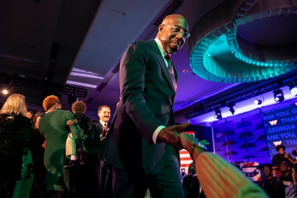 Sen. Raphael Warnock (D-Ga.) shakes hands with supporters after winning his reelection bid for Senate, in Atlanta on Tuesday, Dec. 6, 2022. (Nicole Craine/The New York Times)