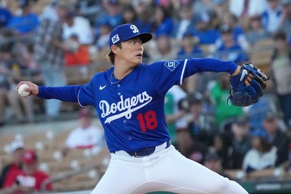 Los Angeles Dodgers pitcher Yoshinobu Yamamoto (18) throws during the first inning of a spring training baseball game against the Cincinnati Reds, Tuesday, March. 4, 2025, in Phoenix. (AP Photo/Darryl Webb)