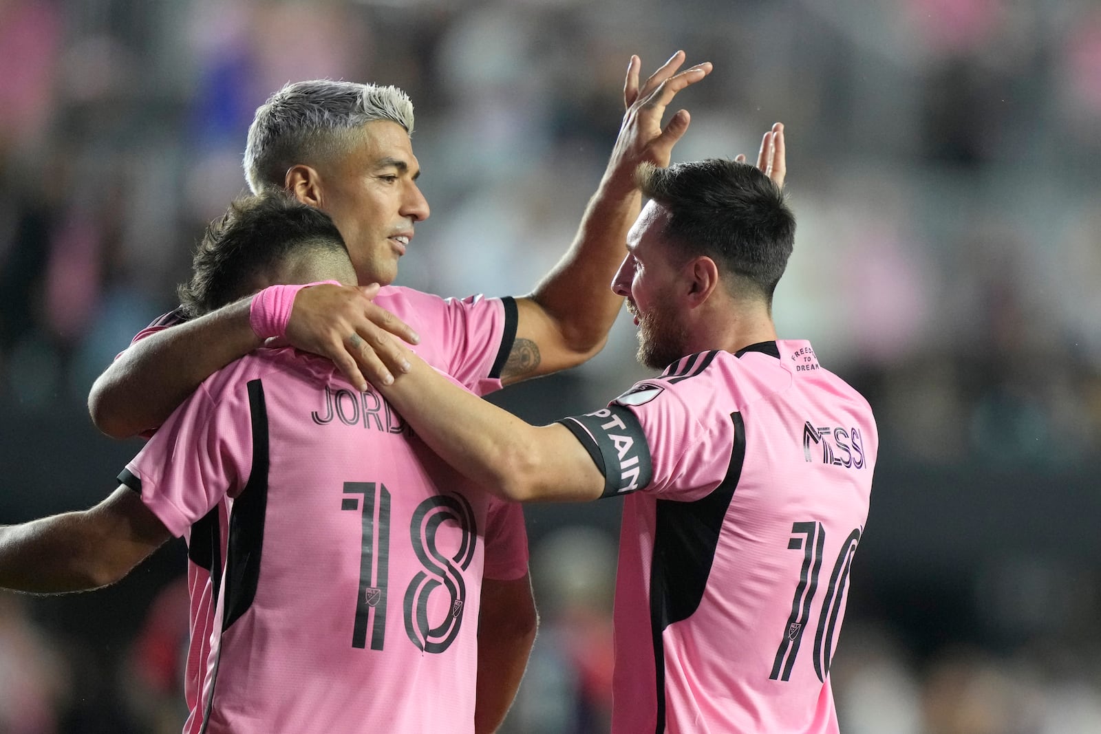 Inter Miami forward Lionel Messi (10) celebrates with Luis Suarez, center, and Jordi Alba (18) after scoring a goal during the second half of an MLS soccer match against the New England Revolution, Saturday, Oct. 19, 2024, in Fort Lauderdale, Fla. (AP Photo/Lynne Sladky)