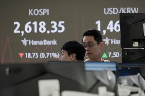 Currency traders work near a screen showing the Korea Composite Stock Price Index (KOSPI), left, and the foreign exchange rate between U.S. dollar and South Korean won at the foreign exchange dealing room of the KEB Hana Bank headquarters in Seoul, South Korea, Friday, March 21, 2025. (AP Photo/Ahn Young-joon)