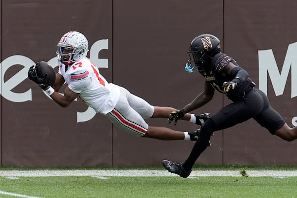 Ohio State wide receiver Carnell Tate State lays out for a touchdown pass as Northwestern defensive back Josh Fussell defends during the first half of an NCAA college football game at Wrigley Field on Saturday, Nov. 16, 2024, in Chicago. (AP Photo/Charles Rex Arbogast)