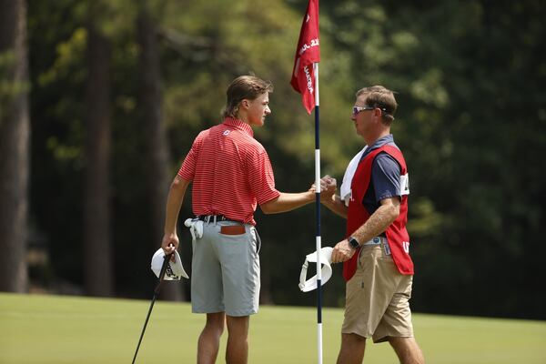 Carter Loflin celebrates with his caddie after winning his match on hole 16 during the round of 64 at the 2021 U.S. Junior at The Country Club of North in Village of Pinehurst, N.C. on Wednesday, July 21, 2021. (Chris Keane/USGA)