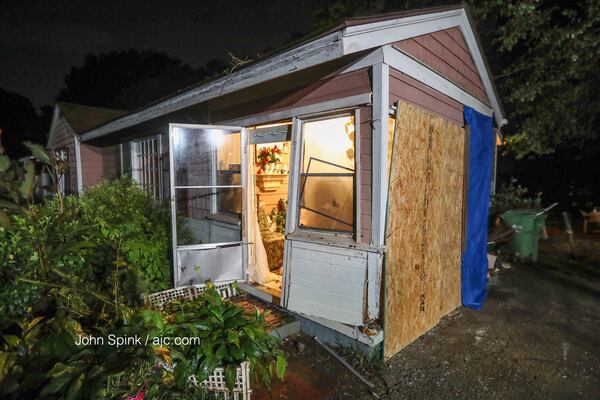 Roxanne Cade and Mary Bledsoe's enclosed patio is boarded up after a car crashed into the side of their southeast Atlanta home Tuesday. JOHN SPINK / JSPINK@AJC.COM