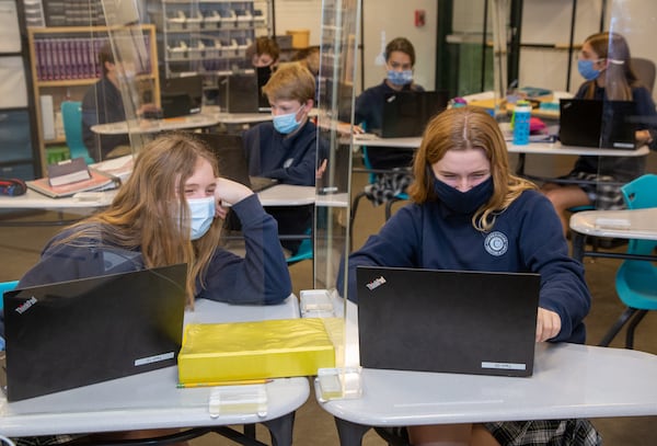 Kaitlyn Moss (left) & Kelsey Brown share a computer screen between plexiglass in Mr Brad LantisÕ technology class at Cornerstone Christian Academy in Peachtree Corners on Monday January 25th, 2021 For a story on the Top Workplace small category. PHIL SKINNER FOR THE ATLANTA JOURNAL-CONSTITUTION.