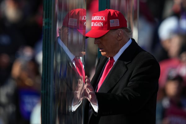 Republican presidential nominee former President Donald Trump is reflected in the bullet proof glass as he finishes speaking at a campaign rally in Lititz, Pa., Sunday, Nov. 3, 2024. (AP Photo/Matt Rourke)