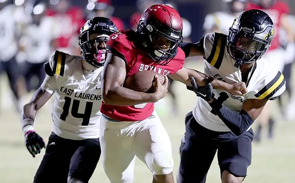 Bryan County's Jacari Carney drags East Laurens defensive back Terrez Snead and Jamichael Carswell (14) to the end zone during Friday Night's game, Nov. 10, 2023, at Bryan County High School.
Richard Burkhart/Savannah Morning News