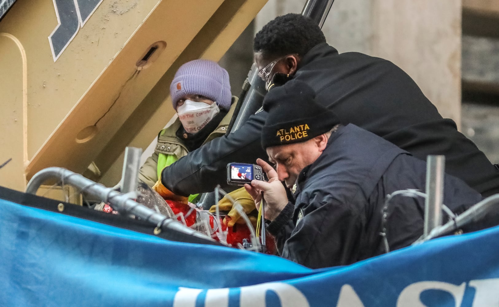 Two people locked themselves to construction equipment in Midtown to protest Atlanta’s planned public safety training center, causing a street to close amid the Monday morning commute, Jan. 29, 2024. The activists used reinforced bindings to lock their arms around the equipment at a Brasfield & Gorrie work site at 12th and Juniper streets. One person was locked to a construction elevator and the other to a boom. Both were released by 10:15 a.m. Juniper Street was closed to traffic for hours Monday morning before reopening around 11:30 a.m. SWAT team members were also at the scene for assistance in cutting the activists free. Brasfield & Gorrie is one of the contractors hired to build the training facility at the site of the old Atlanta Prison Farm in the south DeKalb County woods. Those opposed to the facility say its construction will damage the South River Forest and contribute to what they say is the militarization of the police department. (John Spink / John.Spink@ajc.com)

