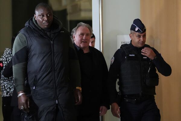 Actor Gerard Depardieu, center, leaves the court after the first day of his trial for the alleged sexual assaults of two women on a film set in 2021, Monday, March 24, 2025 in Paris. (AP Photo/Thibault Camus)