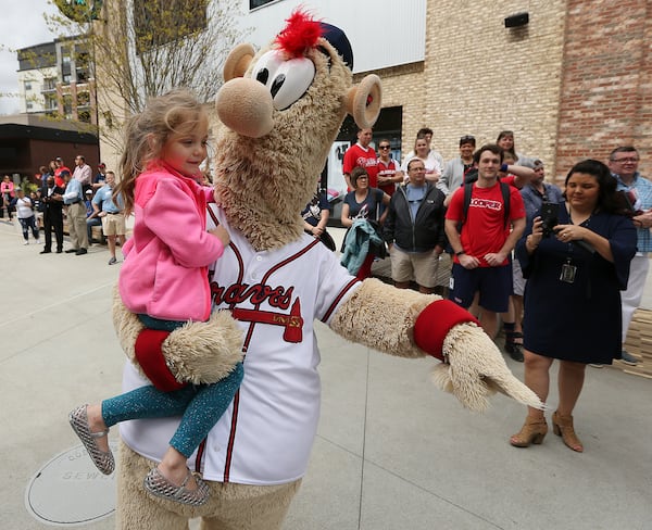 Braves mascot Blooper gives 4-year-old Kenley Moore a lift Thursday's Brave Walk parade. (Curtis Compton/ccompton@ajc.com)