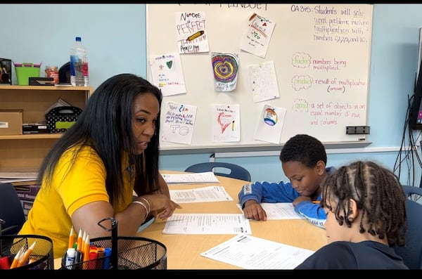 Fourth grade teacher Jasmine Hill works on reading comprehension skills with two students at APS's Academic Recovery Academy at Tuskegee Airmen Global Academy. (Martha Dalton/martha.dalton@ajc.com)