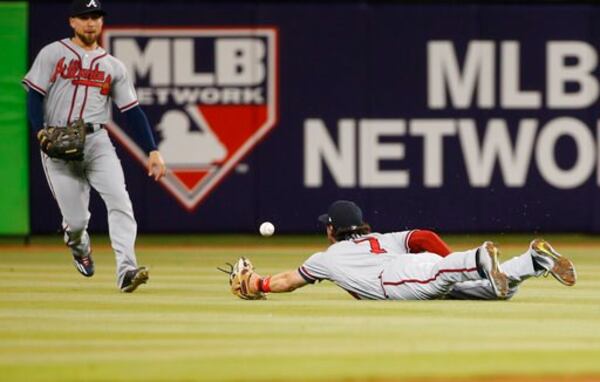  This ball dropped between diving shortstop Dansby Swanson and center field Ender Inciarte in the first inning Tuesday, and things only got worse from there for the Braves and Bartolo Colon. (AP Photo/Wilfredo Lee)