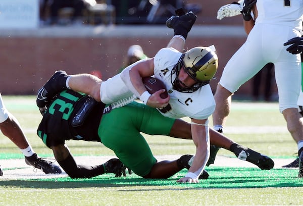 Army quarterback Bryson Daily (13) is tackled by North Texas safety BJ Allen Jr. (30) in the first half of an NCAA football game Saturday, Nov. 9, 2024, in Denton, TX. (AP Photo/Richard W. Rodriguez)