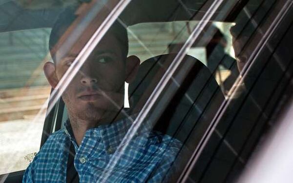 American Olympic swimmers Gunnar Bentz, left, and Jack Conger, in backseat, sit inside a car outside a police station where they were going to provide testimony in Rio de Janeiro, Thursday, Aug. 18, 2016. The two were taken off their flight from Brazil to the U.S. on Wednesday by local authorities amid an investigation into a reported robbery targeting Ryan Lochte and his teammates. A Brazilian police official is telling The Associated Press that American swimmer Lochte fabricated a story about being robbed at gunpoint in Rio de Janeiro. T(AP Photo/Mauro Pimentel)