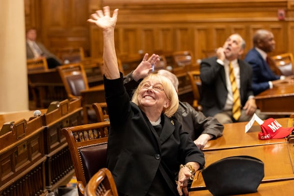 Georgia Republican elector Susan "Suzi" Voyles waves to people in the gallery, as electors gather to formally cast their votes for Donald Trump and JD Vance in the Senate chambers at the Capitol in Atlanta, Tuesday, Dec. 17, 2024. (Arvin Temkar/Atlanta Journal-Constitution via AP)