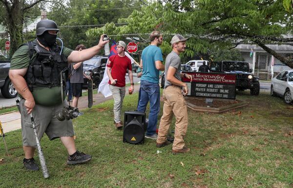 8/15/20 - Stone Mountain, GA - A  protestor sprays a counter protestor with bug spray.  Several far-right groups, including militias and white supremacists, rally Saturday in the town of Stone Mountain, and a broad coalition of leftist anti-racist groups organized a counter-demonstration there after local authorities closed Stone Mountain park.   Alyssa Pointer / alyssa.pointer@ajc.com