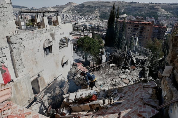 Firemen work at the site of an Israeli missile strike in Damascus, Syria, Thursday March 13, 2025.(AP Photo/Omar Sanadiki)