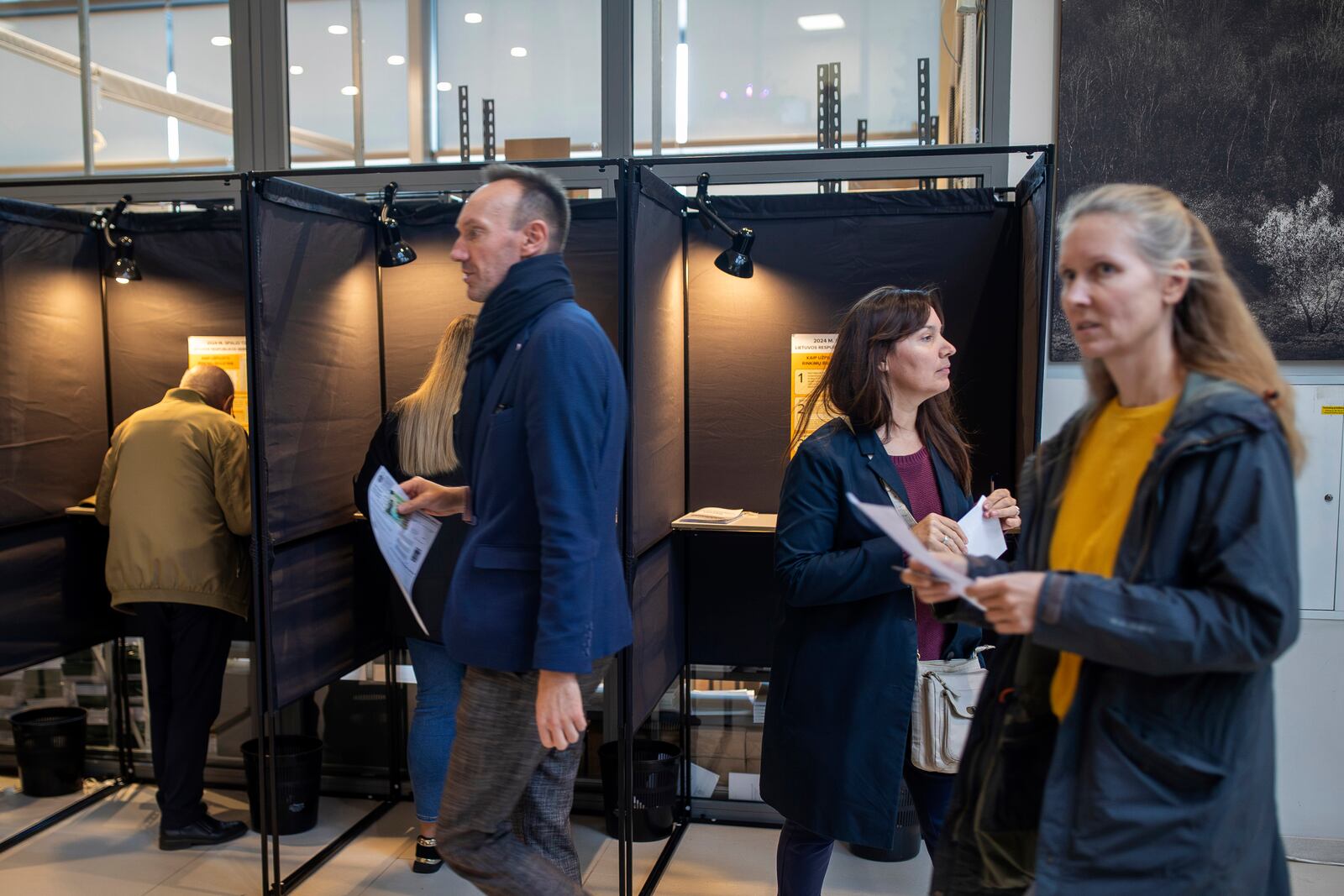 Local residents vote at the polling station during the advance voting in the first round of a parliamentary election in Vilnius, Lithuania, Wednesday, Oct. 9, 2024. (AP Photo/Mindaugas Kulbis)