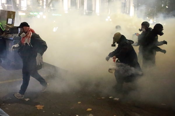 Demonstrators walk trough a cloud of tear gas to continue protests against the government's decision to suspend negotiations on joining the European Union in Tbilisi, Georgia, early Tuesday, Dec. 3, 2024. (AP Photo/Zurab Tsertsvadze)