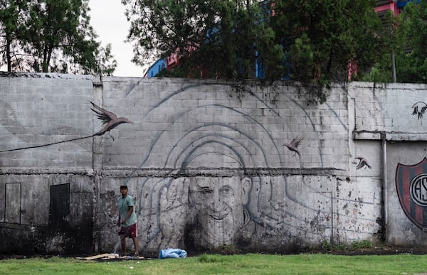 A man stands in front of a mural of Pope Francis outside the stadium of San Lorenzo, his soccer team, in the Padre Ricciardelli neighborhood of Buenos Aires, Argentina, Tuesday, Feb. 25, 2025. (AP Photo/Rodrigo Abd)