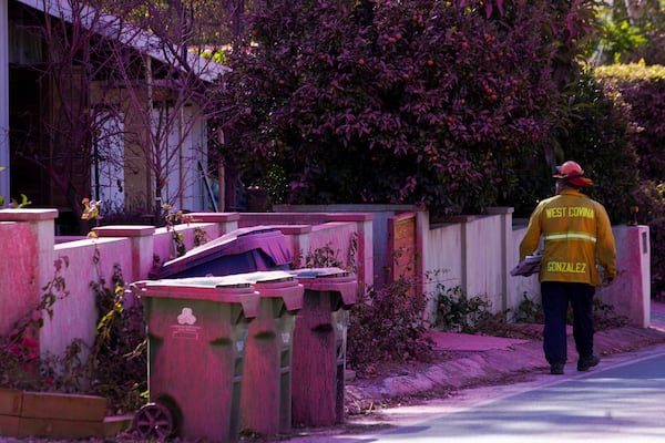 Retardant covers the front of a property after crews battled the Palisades Fire in Mandeville Canyon Monday, Jan. 13, 2025, in Los Angeles. (AP Photo/Richard Vogel)