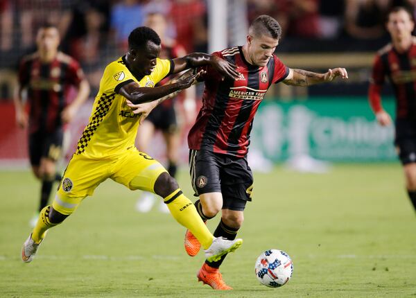 Atlanta United defender Greg Garza (4) is challenged by Columbus Crew midfielder Mohammed Abu (8) in the second half of an MLS soccer match, Saturday, June 17, 2017, in Atlanta . Atlanta won 3-1. (AP Photo/John Bazemore)