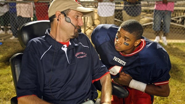 Using a motorized wheelchair, Greenville coach Jeremy Williams talks with quarterback Mario Alford during their win against Macon County Sept. 17, 2010, in Greenville.