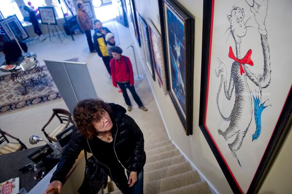 Delanna Protas looks at artwork on display for the "Hats Off to Dr. Seuss" national traveling exhibit at the Ann Jackson Gallery in Roswell on Sunday, Feb. 16, 2014. The exhibit features numerous hats created by the children's author. JONATHAN PHILLIPS / SPECIAL