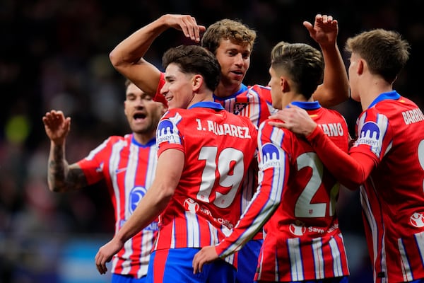 Atletico Madrid's Julian Alvarez (19) celebrates with teammates after scoring the opening goal during the Champions League opening phase soccer match between Atletico Madrid and Slovan Bratislava at Riyadh Air Metropolitano stadium in Madrid, Spain, Wednesday, Dec. 11, 2024. (AP Photo/Manu Fernandez)