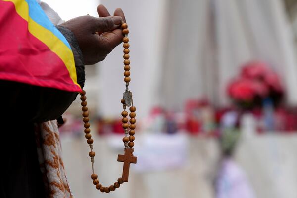 A woman holds rosary beads as she prays for Pope Francis in front of the Agostino Gemelli Polyclinic, where the Pontiff has been hospitalized since Feb.14, in Rome, Saturday, March 1, 2025. (AP Photo/Kirsty Wigglesworth)