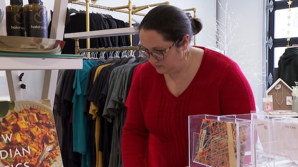 In this image made from video, Whiskeyjack Boutique owner Katie Stokes arranges items for sale at her gift shop Tuesday, March 4, 2025, in Windsor, Ontario. (AP Photo/Mike Householder)