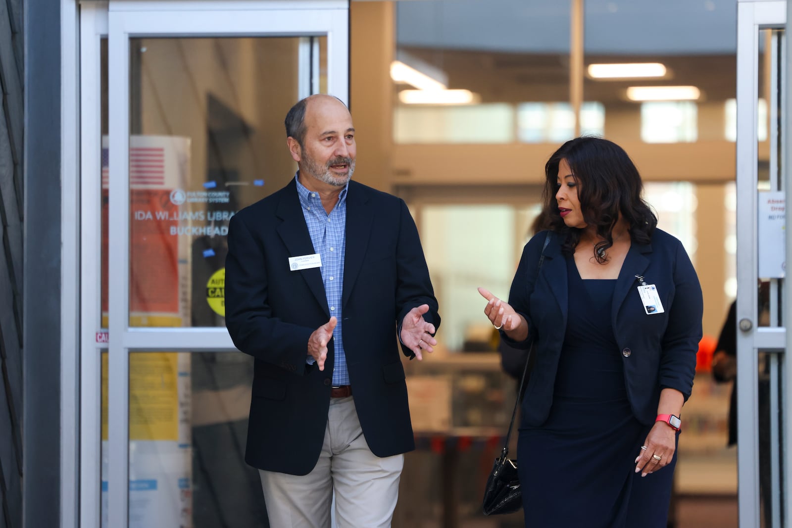 State Election Board Chair John Fervier, left, and Fulton County Election Board Chair Sherri Allen walk out of the Buckhead Library after visiting an early voting location in October.