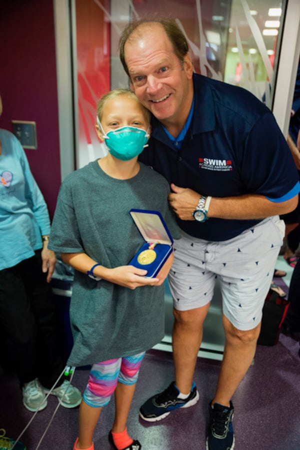 Steve Lundquist is pictured here with a pediatric cancer patient at the Aflac Cancer and Blood Disorders Center of Children’s Healthcare of Atlanta, the beneficiary of the Atlanta Swim Across America annual event. Courtesy of Swim Across America