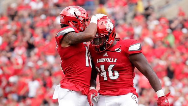 Jaire Alexander #10 and Lamar Atkins #46 of the Louisville Cardinals celebrate.