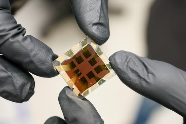 Juan-Pablo Correa-Baena, an associate professor at Georgia Tech, shows a close-up of a finished solar chip made with perovskite. (Miguel Martinez/AJC)