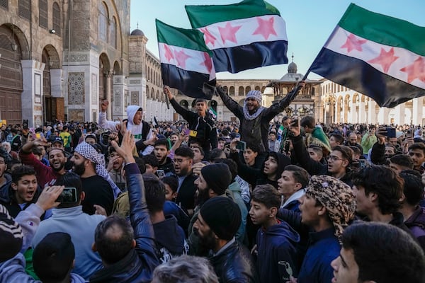 Syrians chant slogans and wave the new Syrian flag as they gather for Friday prayers at the Umayyad mosque in Damascus, Syria, Friday, Dec. 12, 2024. (AP Photo/Leo Correa)