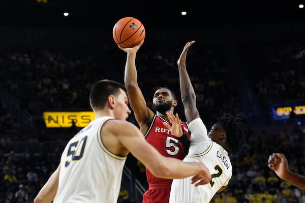 Rutgers guard Tyson Acuff (5) shoots past Michigan guard L.J. Cason, right, and center Vladislav Goldin during the first half of an NCAA college basketball game, Thursday, Feb. 27, 2025, in Ann Arbor, Mich. (AP Photo/Jose Juarez)