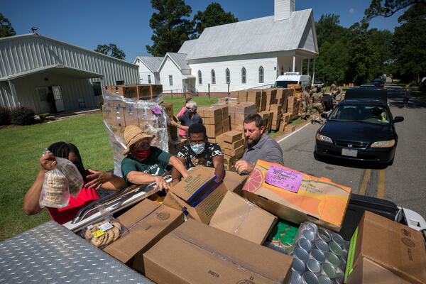 Volunteers load the bed of a pickup truck with food. (AJC Photo/Stephen B. Morton)