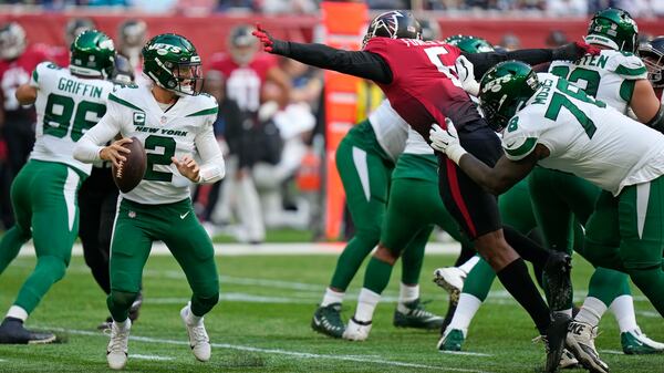 New York Jets quarterback Zach Wilson (2) is pressured by Falcons defensive lineman Dante Fowler (6) Sunday, Oct. 10, 2021, at the Tottenham Hotspur stadium in London, England. (Alastair Grant/AP)