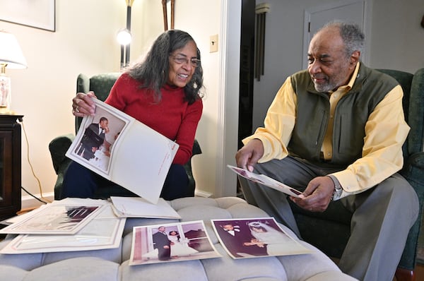 Gwen and James Middlebrooks look through their wedding photographs at their home in Atlanta. Hyosub Shin / Hyosub.Shin@ajc.com