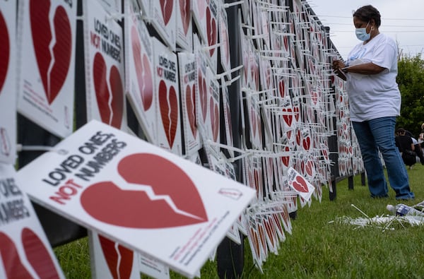 Catolyn Merriweather, whose mother JoeAnn Snead died from COVID-19 in April, helps hang 5,000 broken hearts on the fence outside of the National Museum for Civil and Human Rights in Atlanta on Thursday evening Aug. 27, 2020, as part of the “Loved Ones, Not Numbers” campaign to humanize the toll of the current pandemic. Ben Gray for the Atlanta Journal-Constitution