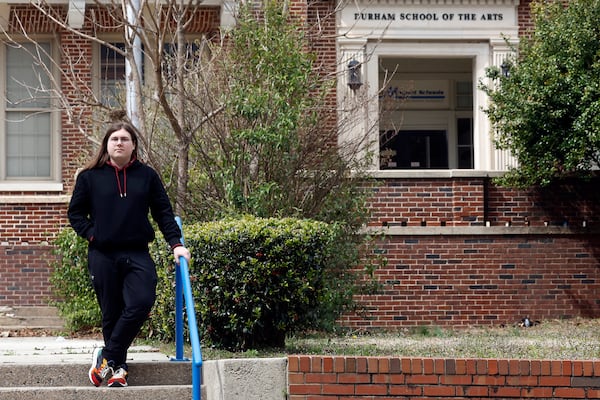 Glenn Thompson, a Durham School of the Arts graduate, poses in front of the school in Durham, N.C., Monday, March 10, 2025. (AP Photo/Karl DeBlaker)