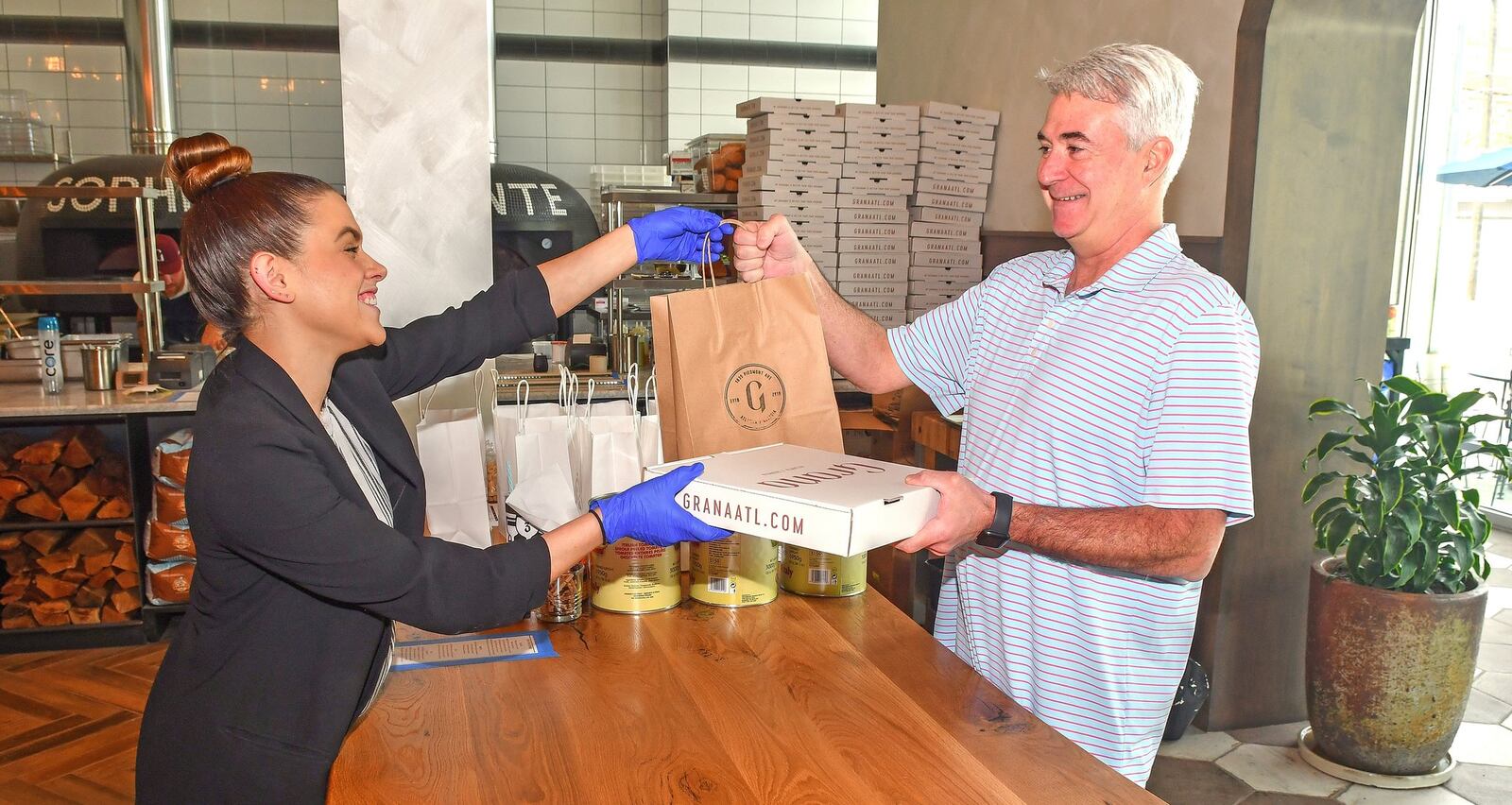 Assistant general manager, Sophia Rosen (left) with take-out customer Leo Bull, who lives nearby in Morningside. CONTRIBUTED BY CHRIS HUNT PHOTOGRAPH