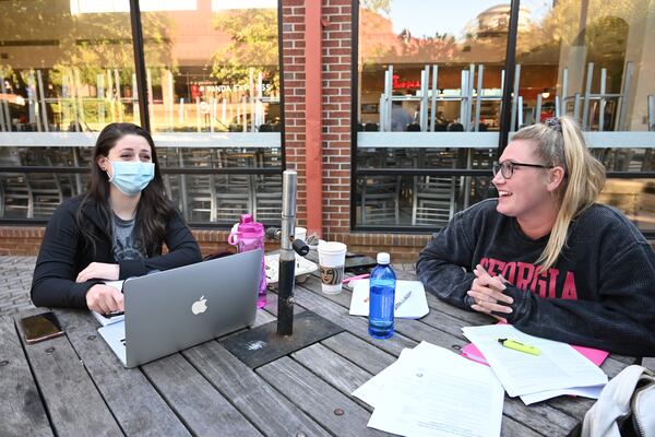 University of Georgia doctoral students Krissa Nakos (left) and Molly Ahearne talk as they study on patio table in University of Georgia campus in Athens on  Oct. 16, 2020. (Hyosub Shin / Hyosub.Shin@ajc.com)