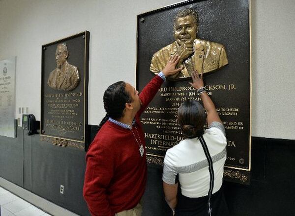 In 2014, Maynard H. Jackson III, left, and Candace Byrd, then Chief of Staff for Atlanta Mayor Kasim Reed, touch a newly unveiled bronze relief plaque of Jackson’s father, Maynard Jackson, created by local artist Fred Ajanogha. (Brant Sanderlin/AJC 2014 photo)