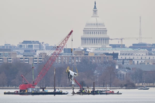 A crane removes airplane wreckage from the Potomac River, where American Airlines flight 5342 collided with a U.S. Army military helicopter, near Ronald Reagan Washington National Airport in Arlington, Virginia, on Feb. 3, 2025. (Roberto Schmidt/AFP/Getty Images/TNS)